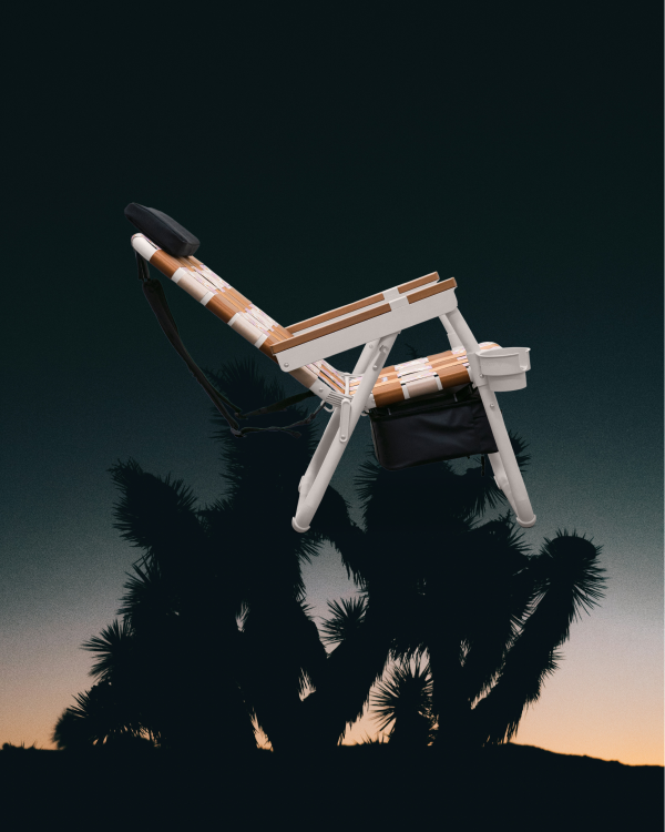 Stylized product shot of PARKIT Eclipse Recliner outdoor adventure chair, set against Joshua Tree desert sunset.