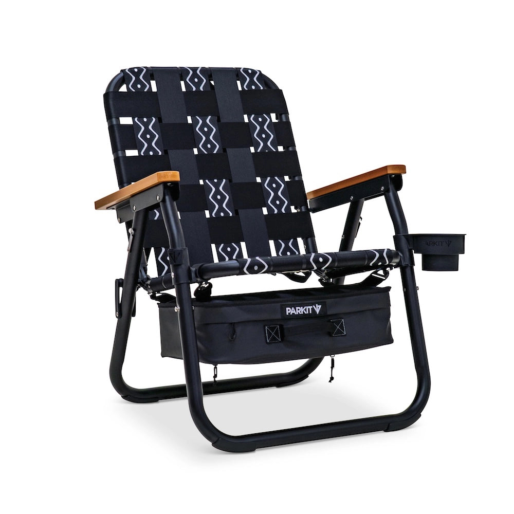 PARKIT Voyager Chair in Slate pattern featuring black and gray woven webbing with geometric detailing, matte black steel frame, wooden armrests, built-in cooler, cup holder, and backpack straps, rugged 3-in-1 outdoor chair designed for comfort, durability, and adventure.