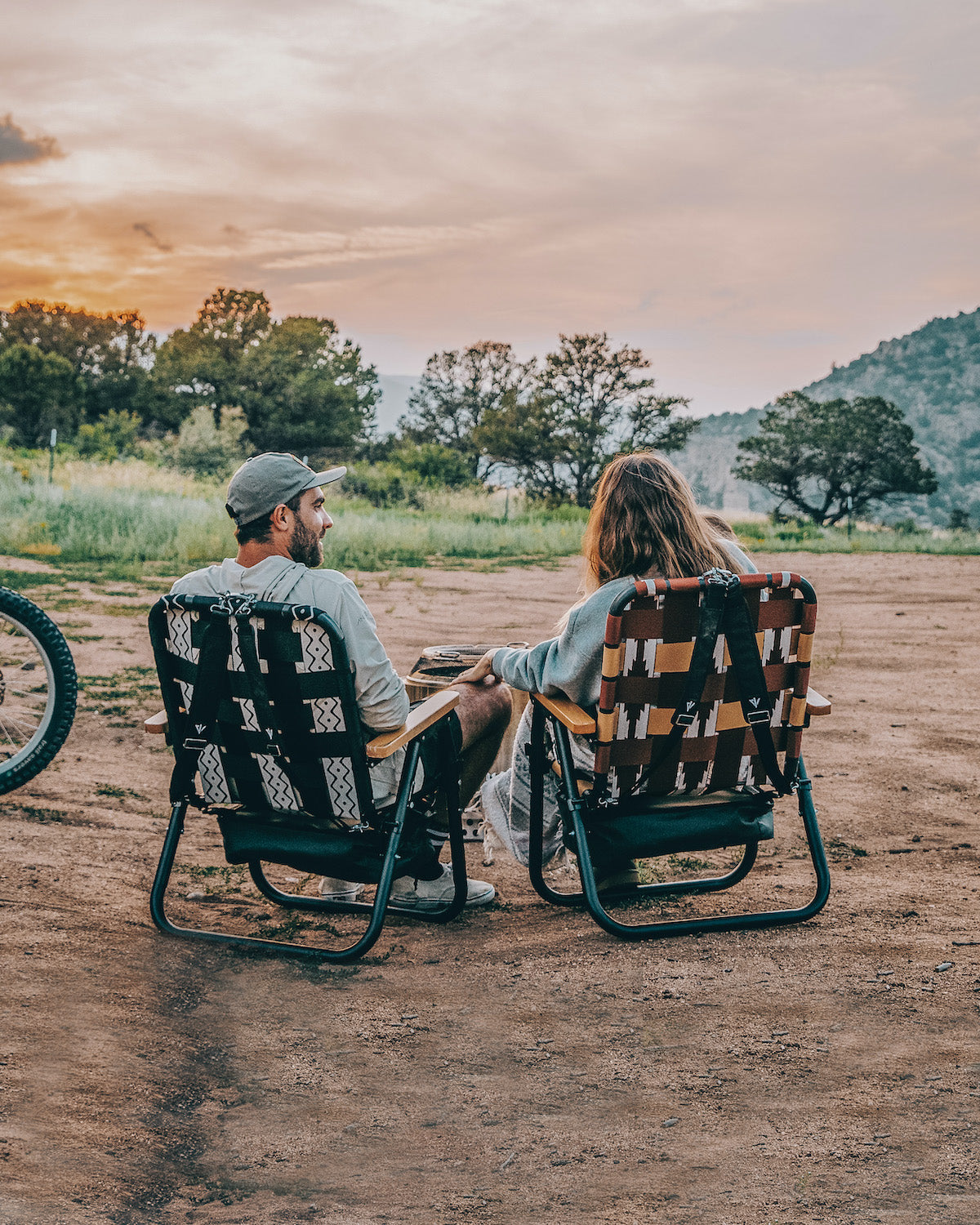 A couple sitting in their Voyager Outdoor Chairs while watching the sun set in the mountains of Colorado.