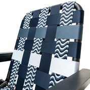 Close-up of a woven seat webbing with a wavy blue and white pattern on a chair, mixed with other ocean blues