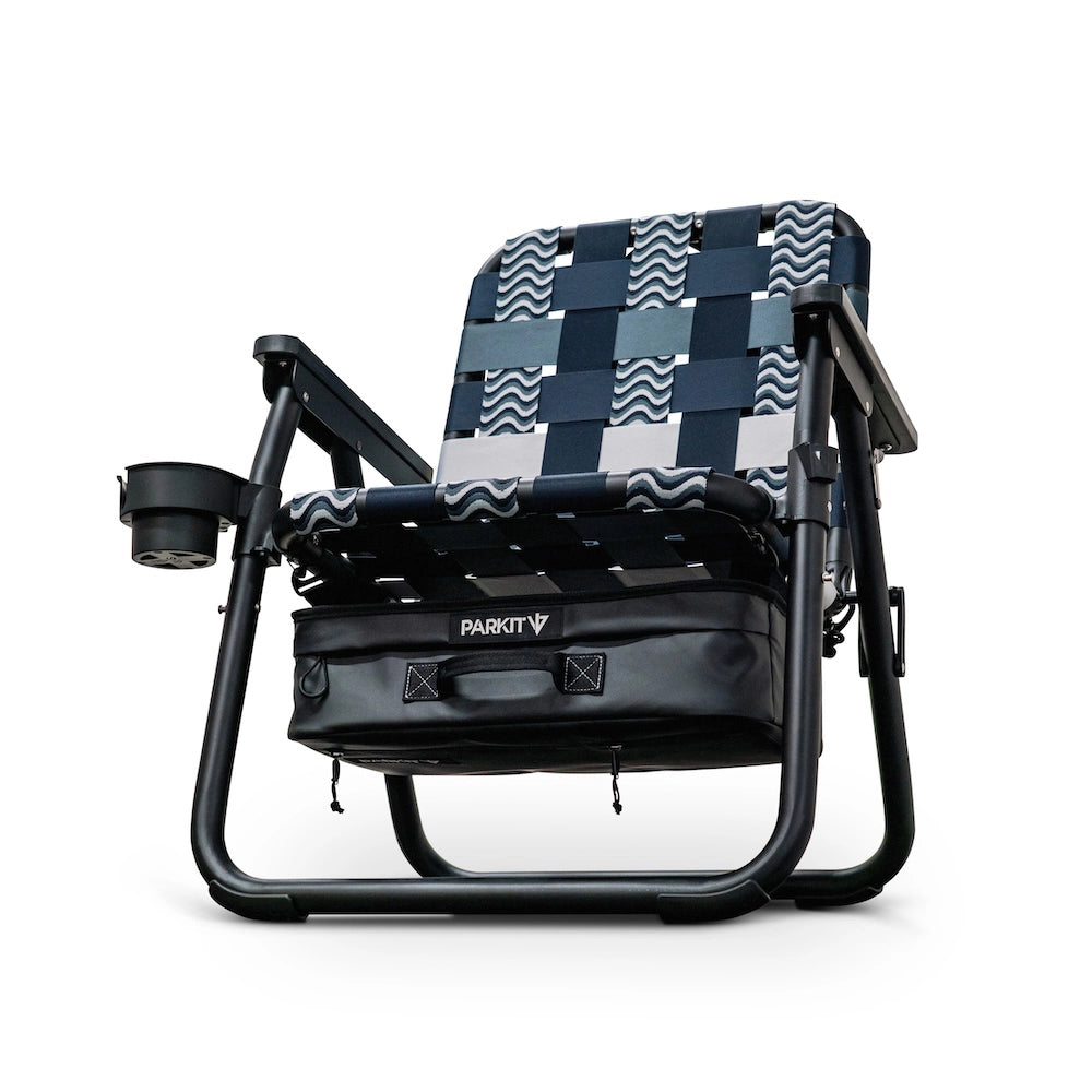 Foldable chair with blue & white wavy pattern and black carrying bag that serves as a cooler on a white background