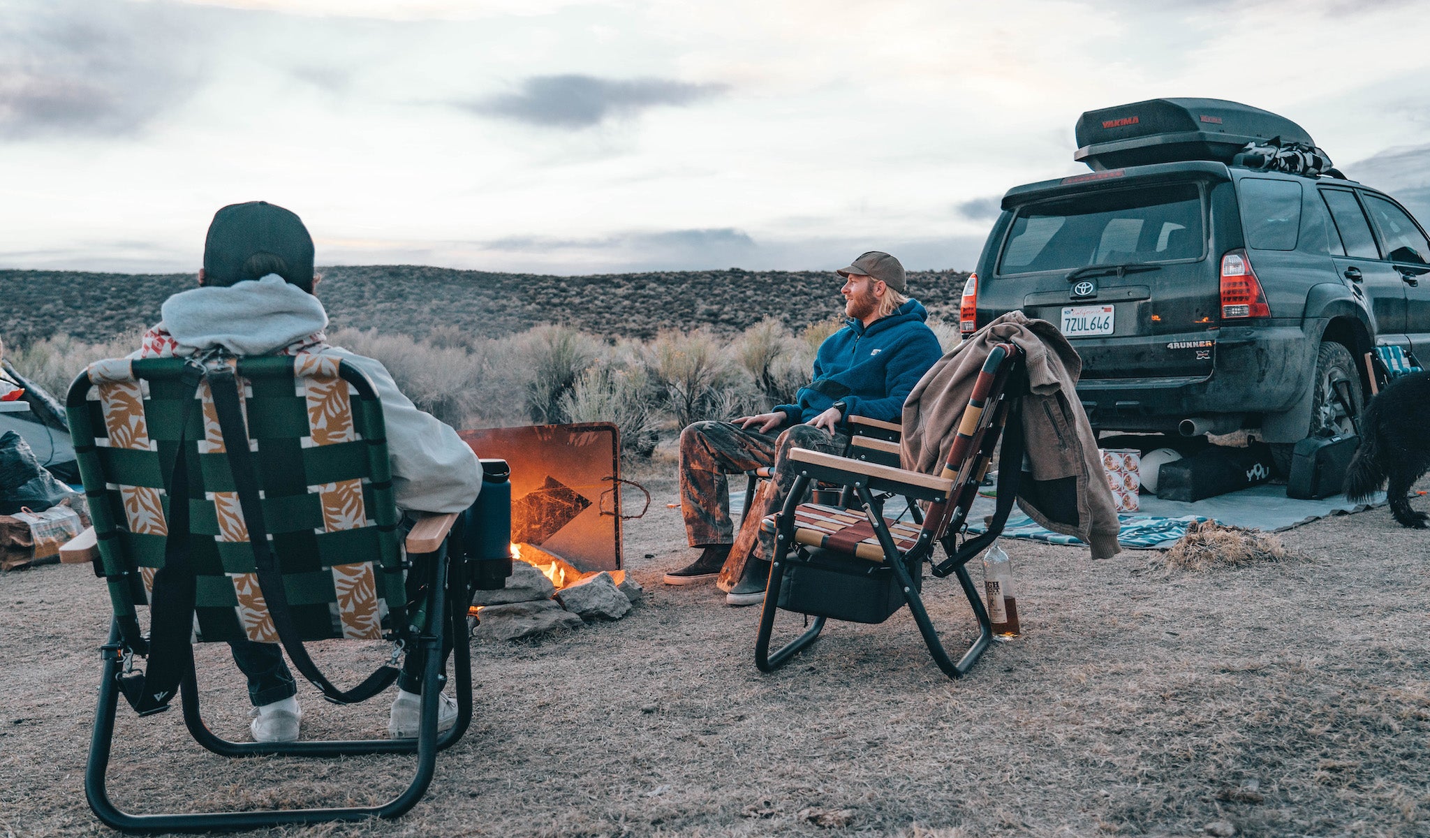 2 Men sitting around the campfire in Mammoth Lakes California with 3 Voyager Chairs in Slate, Tropic, and Calico.