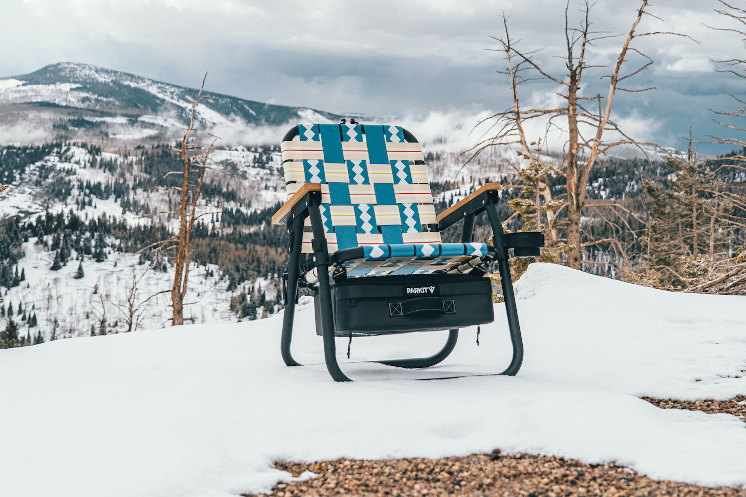 The PARKIT Voyager outdoor chair in classic Blue sitting in the snow on a mountain outside of Zion National park during the winter